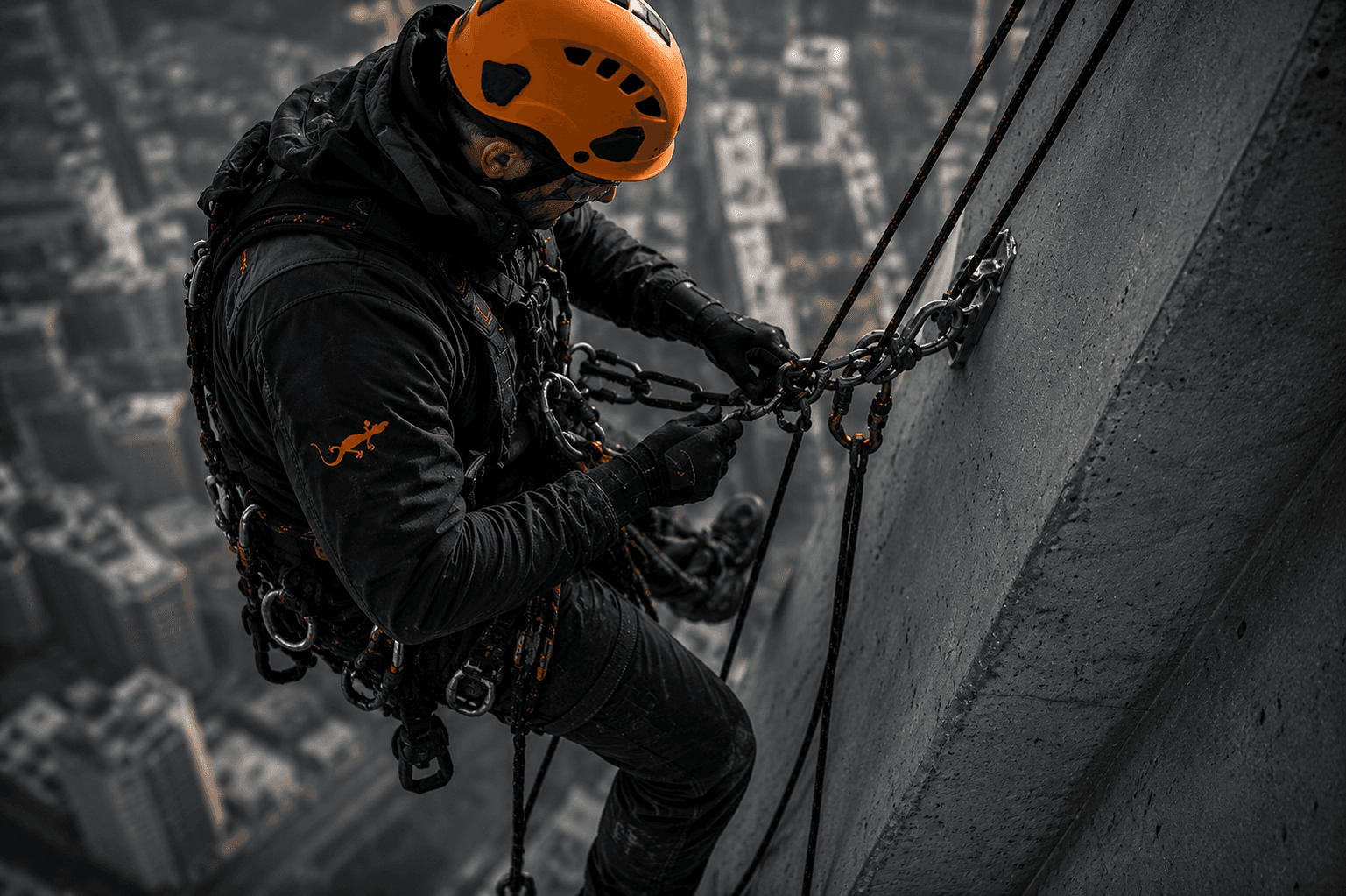 Cordiste en plongée verticale sur une tour de verre, ville en contrebas